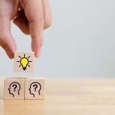 Concept creative idea and innovation. Hand choose a wooden cube block with light bulb and head human symbol icon